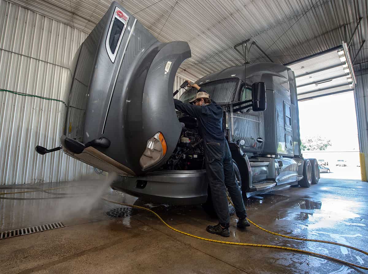 A Midwest driver rinses out the hood of his truck at a Midwest truck wash bay.