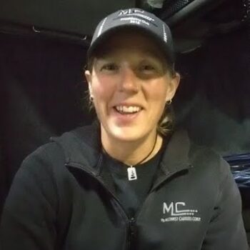 Female truck driver smiling in truck cab