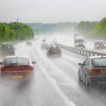 Cars driving on a highway during a heavy shower